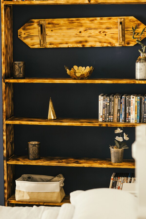 Una estantería con varios objetos, incluyendo libros, un cuenco decorativo y una planta pequeña.