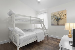 A bunk bed with white bedding, a desk with a lamp, and a painting on the wall. - The Aurelia House | Elegant South Lakeland (Lakeland)