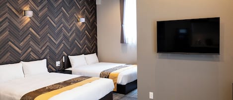 Habitación de hotel con dos camas, televisión, pared con motivo de espiga y ventana con cortinas.