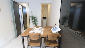 Ein Essbereich mit einem Holztisch, vier Stühlen und einem Tablet-Gerät.