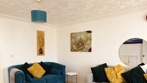 Un saló amb dos sofàs, una taula rodona petita i decoració mural.
