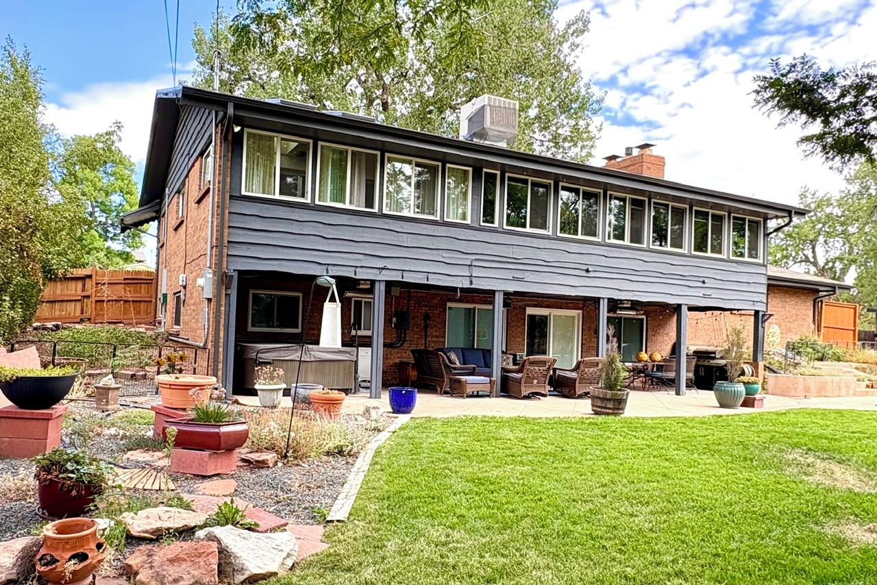 Ein modernes, zweistöckiges Haus mit einer überdachten Terrasse.