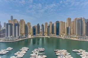 Un port de plaisance où sont amarrés de nombreux bateaux, entouré de grands immeubles.