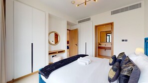 A hotel room with a bed, a bedside table, a mirror, a wardrobe, and a bathroom visible through an open door. - 1 Bed City and Marina Views l Vida Residences (Dubai Marina)