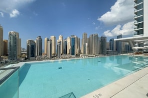 En swimmingpool med stadens silhuett som bakgrund.
