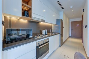 Uma cozinha moderna com micro-ondas, fogão e forno embutidos.
