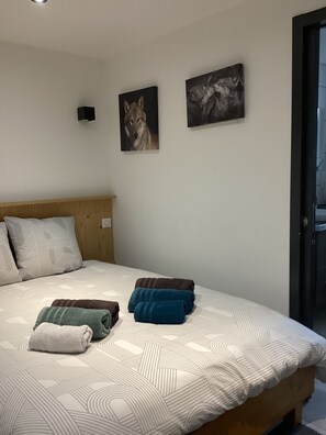 Ein Schlafzimmer mit einem Bett, Kissen und zwei Wandbildern.