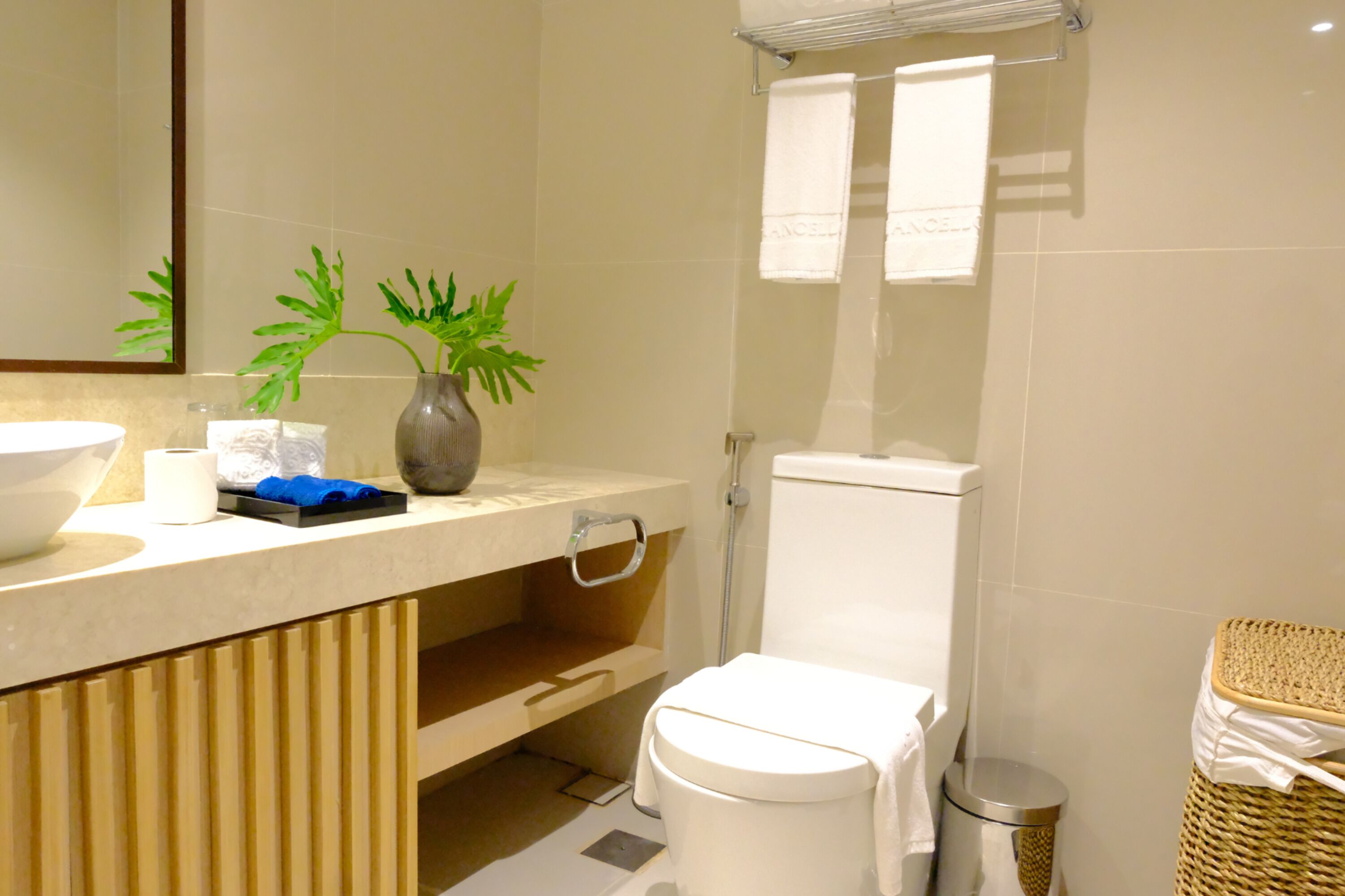 A bathroom with a toilet, bidet, sink, and a mirror.