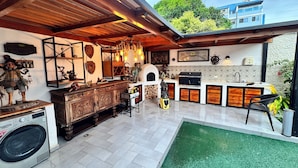 A kitchen with a built-in grill, a washing machine, and a rustic wooden cabinet.