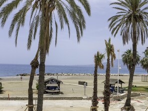 Eine Strandansicht mit Palmen, einem kleinen Boot und einem Schild mit der Aufschrift 'Las Palmas'.