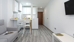 A modern apartment with a kitchenette, a dining area, and a living room. - Sunstay Lovely Loft Fuengirola (Fuengirola)