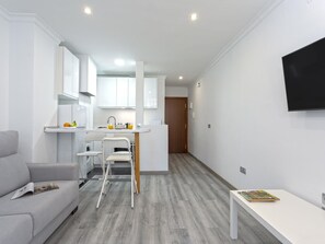 Eine moderne Wohnung mit einer Küchenzeile, einem Essbereich und einem Wohnzimmer.