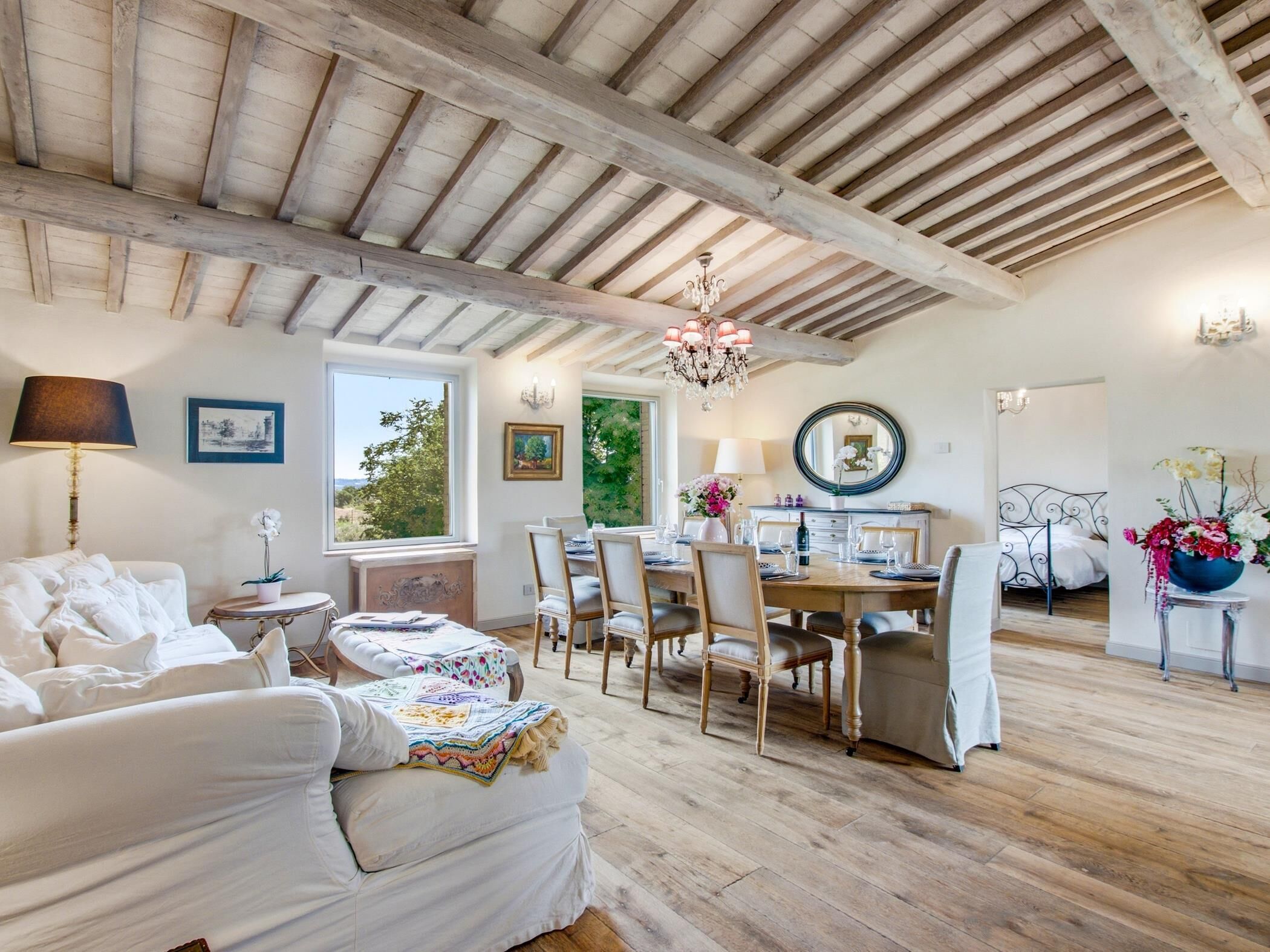 Una habitación con comedor, sofá, cama y un amplio ventanal.