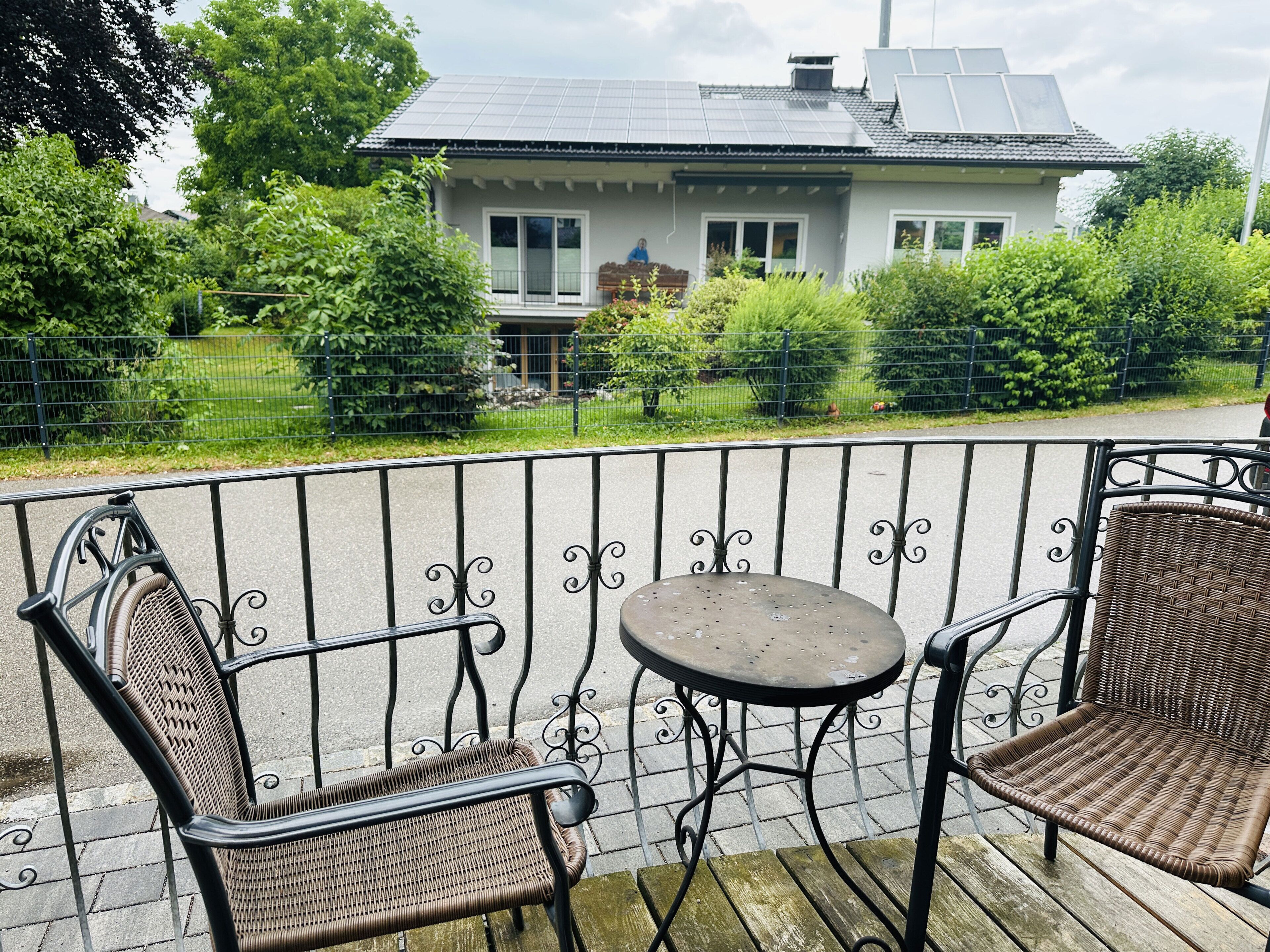 A balcony with wicker chairs and a small round table.