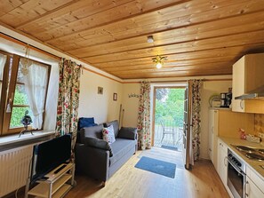 Ein gemütliches Blockhaus-Interieur mit Wohnbereich, Essbereich und Blick durch die Tür.