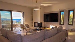 Un salon moderne avec un canapé, un téléviseur et un coin repas.