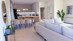 Un intérieur moderne comprenant un coin repas, un canapé et une cuisine.