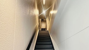 Una escalera moderna con peldaños alfombrados y paredes blancas.