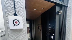 Entrada de un edificio moderno con el logotipo de Target, techo de madera y una puerta negra.