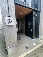 Ein moderner Gebäudeeingang mit Target-Logo, Holzboden und einer schwarzen Tür.
