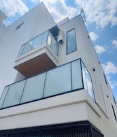 Un edificio moderno con techo plano, amplias ventanas y una antena parabólica.