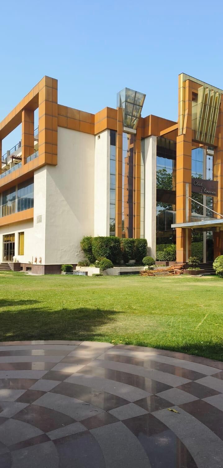 A modern building with a flat roof, large windows, and a checkered floor pattern.