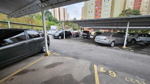 Een parkeerplaats met meerdere auto's en een overdekte constructie.