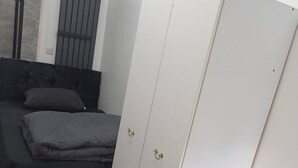 Une pièce comprenant un lit, une armoire et une petite table en bois.