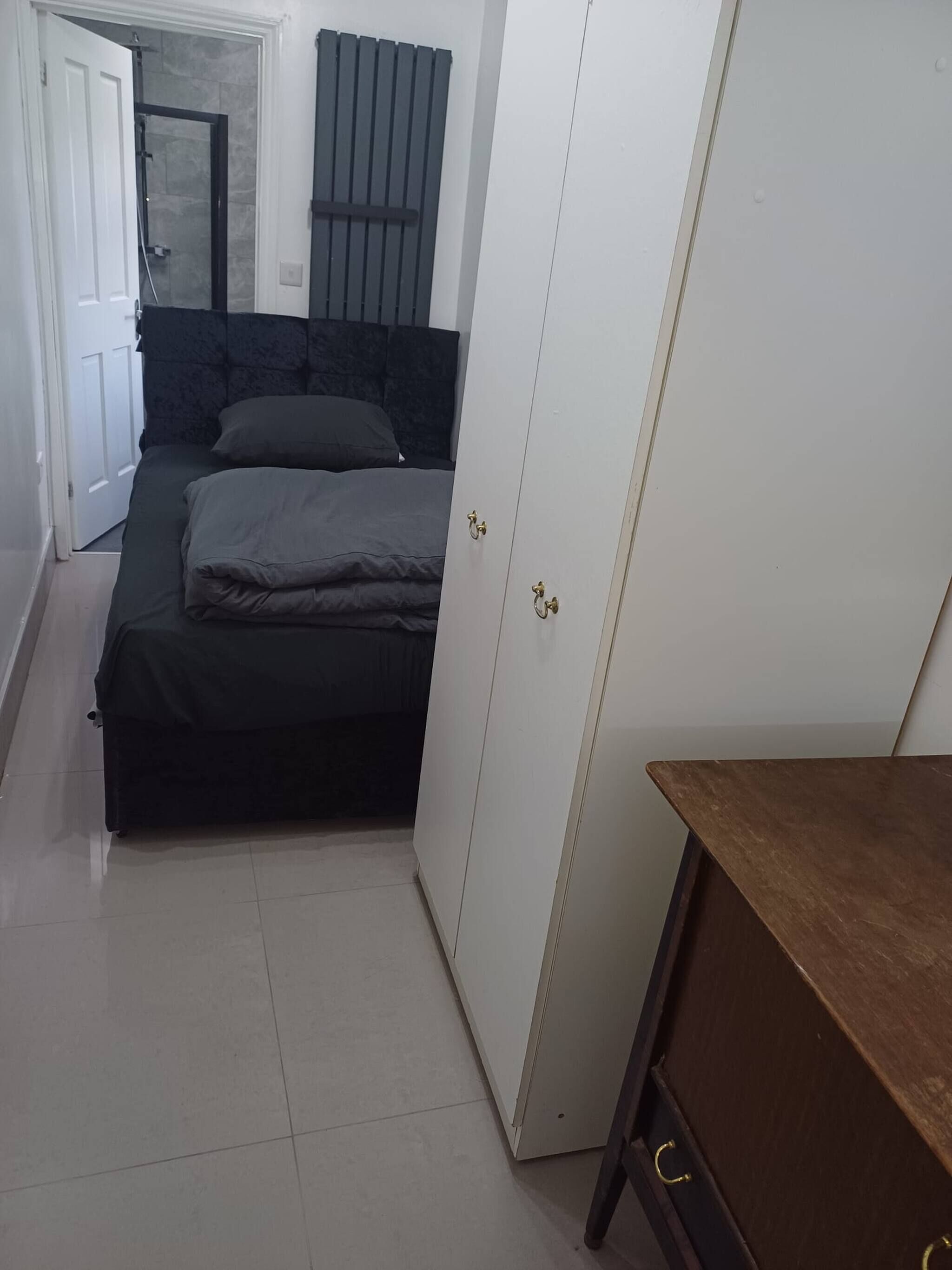 Um quarto com uma cama, um guarda-roupa e uma porta que dá para um banheiro.