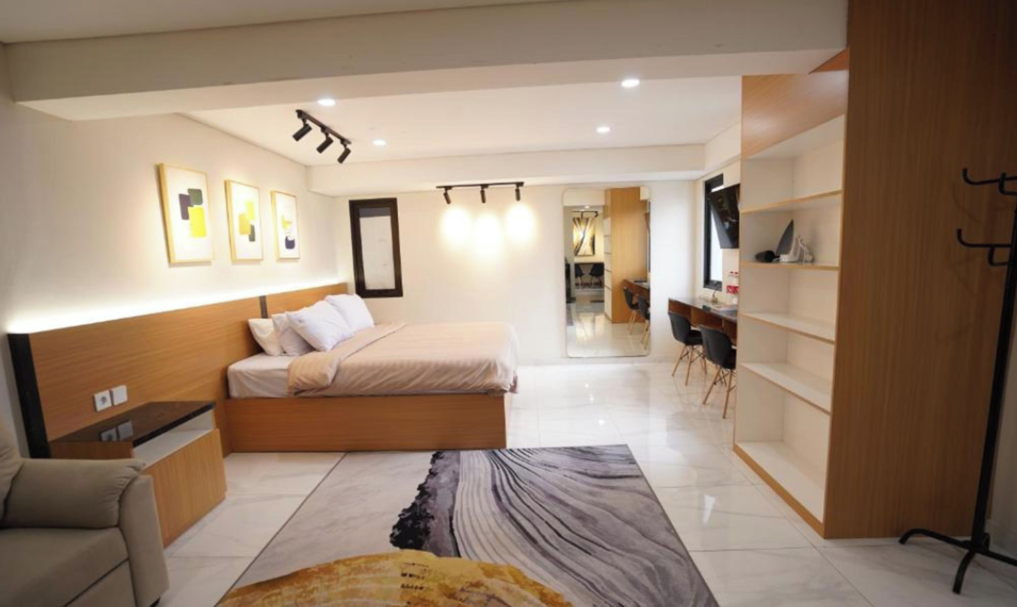 A modern bedroom with a bed, bedside tables, a desk, and a chair.