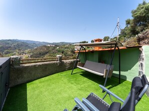 A rooftop terrace with artificial grass, a swing chair, and a view of the surrounding landscape. - Vivelorural Casa Priya Pool and Views (Teror)
