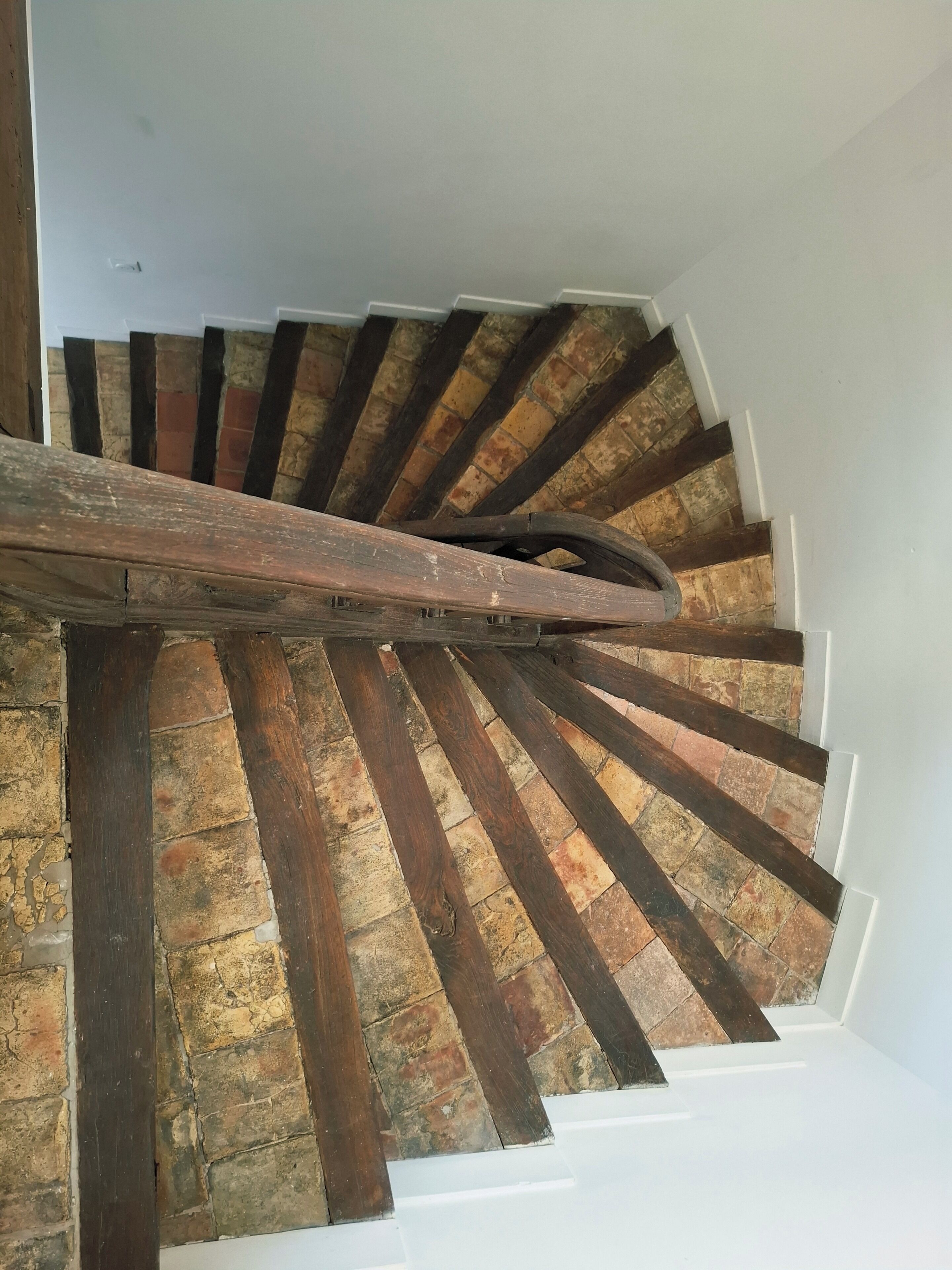Eine Wendeltreppe mit Holzstufen und einer weißen Wand.