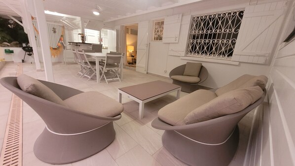 A modern living room with a sofa set, a coffee table, and a dining area with chairs and a table.