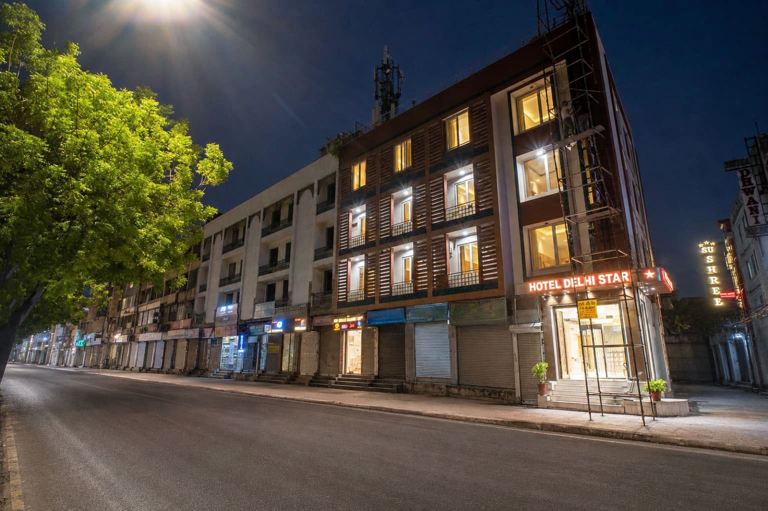 A multi-story hotel with a prominent sign reading 'HOTEL DELHI STAR' at night.