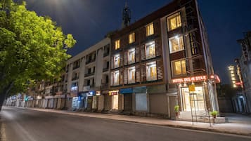 A multi-story hotel with a prominent sign reading 'HOTEL DELHI STAR' at night.