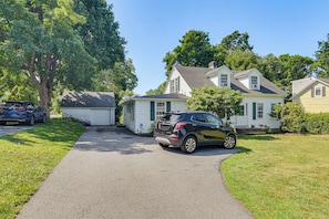 A residential street with houses, a driveway, and a parked car. - Serene Coastal Getaway: 2 Mi to Newport & Beaches (Middletown)