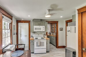 A kitchen with a stove, microwave, and cabinets. - Serene Coastal Getaway: 2 Mi to Newport & Beaches (Middletown)