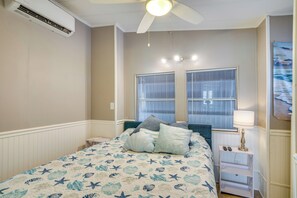 A bedroom with a bed, a nightstand, a lamp, a ceiling fan, and two windows with blinds. - Relaxed Resort-Style Living Near Fort Myers Beach (Fort Myers)