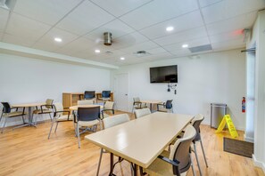 A conference room with a large table, chairs, a television, and a fire extinguisher. - Relaxed Resort-Style Living Near Fort Myers Beach (Fort Myers)