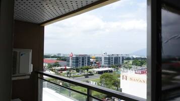 A room with a view of a cityscape, including a McDonald's and a building with a sign that reads 'SAVAN.'