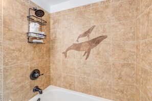 A bathroom with a shower, a towel rack, and a dolphin mural on the wall. - Ocean-view 1BR condo with pool, AC and beach access-Maalaea Banyans 112 (Wailuku)