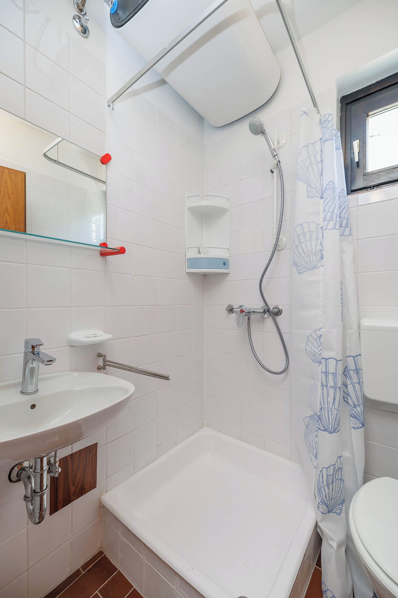 Kylpyhuone, jossa on kylpyamme, pesuallas, suihku ja wc.