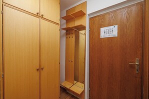 A wooden wardrobe with multiple doors and a mirror. - Serene Studio Escape in Malinska with Modern Comforts (Malinska-Dubašnica)