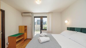Ett hotellrum med en säng, ett skrivbord, en luftkonditioneringsanläggning och utsikt över omgivningarna.