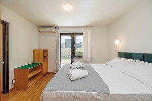Ein Hotelzimmer mit Bett, Schreibtisch, Klimaanlage und Blick ins Freie.