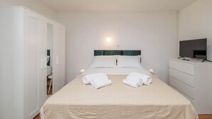 A hotel room with a bed, a television, a wardrobe, and a desk. - Charming Studio in Malinska (Malinska-Dubašnica)