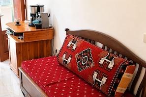 A wooden bed with a red patterned pillow and a matching red bedspread. - Villa Günbatımı (Kaş)
