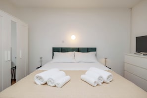 A hotel room with a bed, two bedside tables, a TV, and a wardrobe. - Moder studio for 2 persons in Malinska, island of Krk (Malinska-Dubašnica)