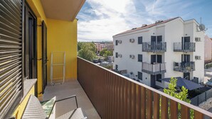Un balcon donnant sur un immeuble doté de balcons et de climatiseurs.