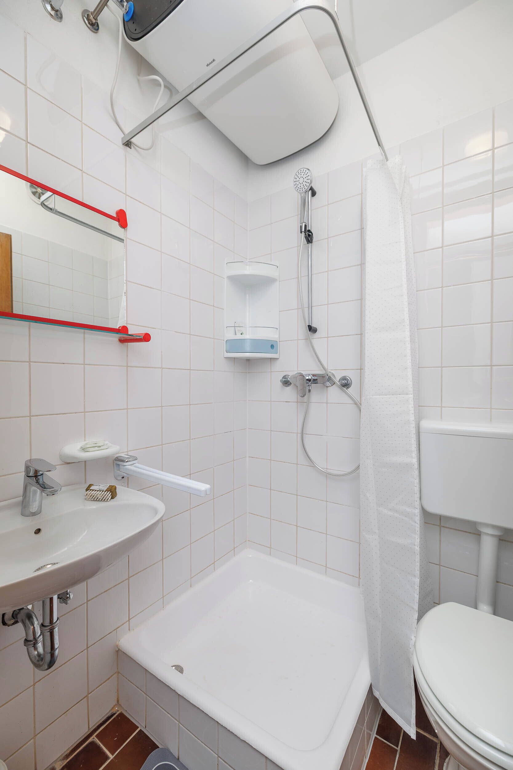 Un baño con lavamanos blanco, bañera, ducha e inodoro.